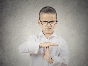 Closeup portrait serious young man, child, making, showing time out gesture with hands, isolated grey wall background. Negative human emotions, facial expressions, feeling, signs symbol body language