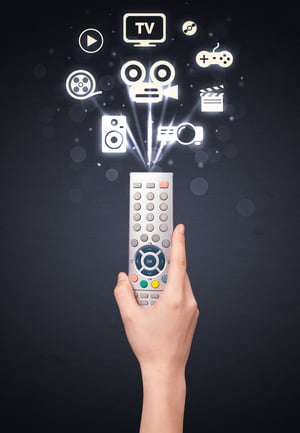 Hand holding a remote control, media icons coming out of it