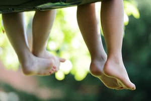 Happy children sitting on green grass outdoors in summer park