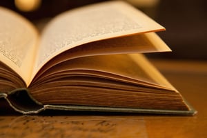 Open old book with warm light on a table-1