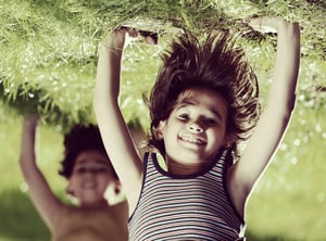 Portraits of happy kids playing upside down outdoors in summer park